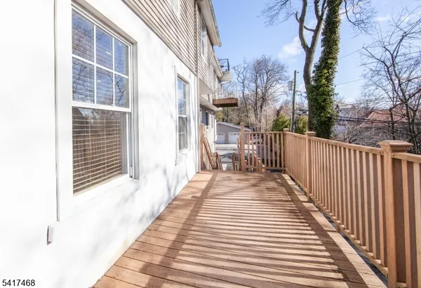 a view of a balcony with wooden floor and fence