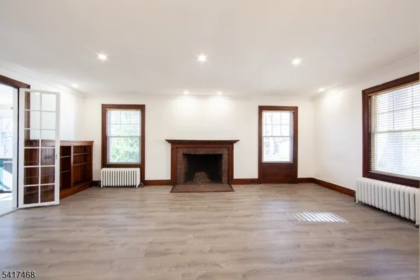 an empty room with windows and fireplace