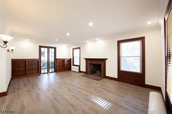 a view of a livingroom with wooden floor and a fireplace