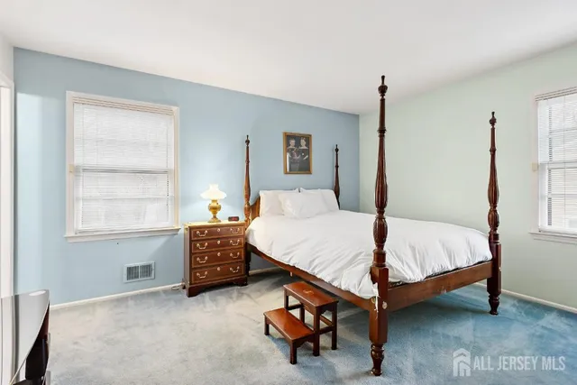 a bed sitting in a bedroom next to a window