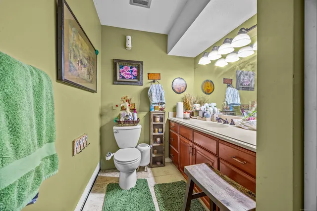 a bathroom with a sink mirror vanity and toilet