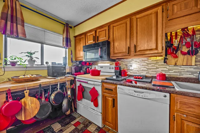 a utility room with stainless steel appliances granite countertop a stove and cabinets