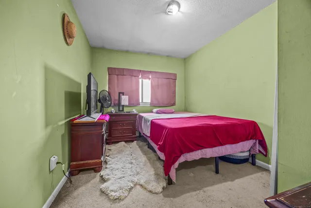 a spacious bedroom with a bed and a mirror