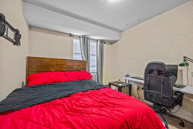 a bedroom with a bed and a large window