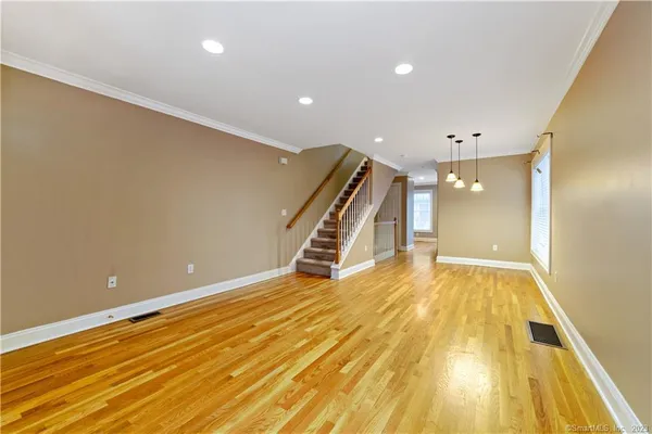 a view of an empty room with wooden floor