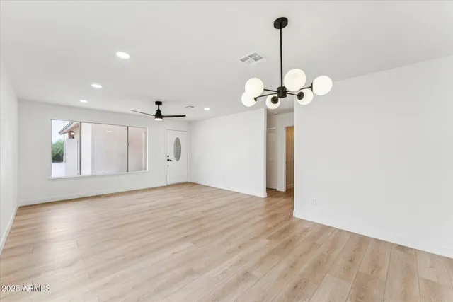 a view of a room with wooden floor chandelier and entryway