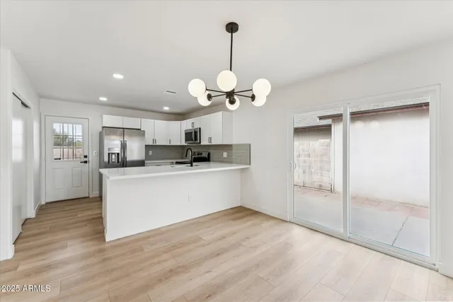 a large kitchen with white cabinets and stainless steel appliances