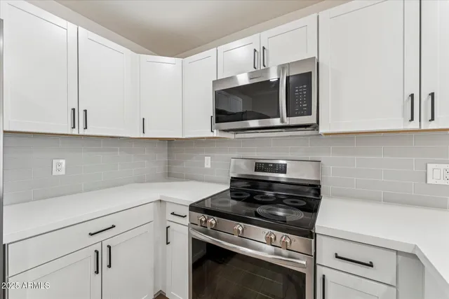 a kitchen with white cabinets and appliances