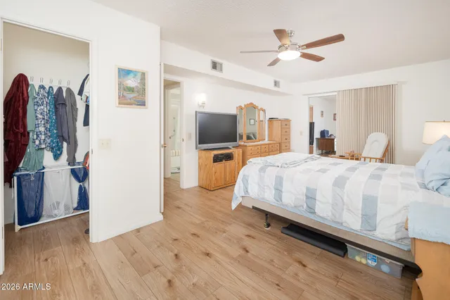 a spacious bedroom with a bed and a flat screen tv