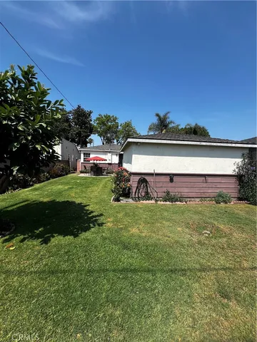 a view of a big house with a big yard and large trees