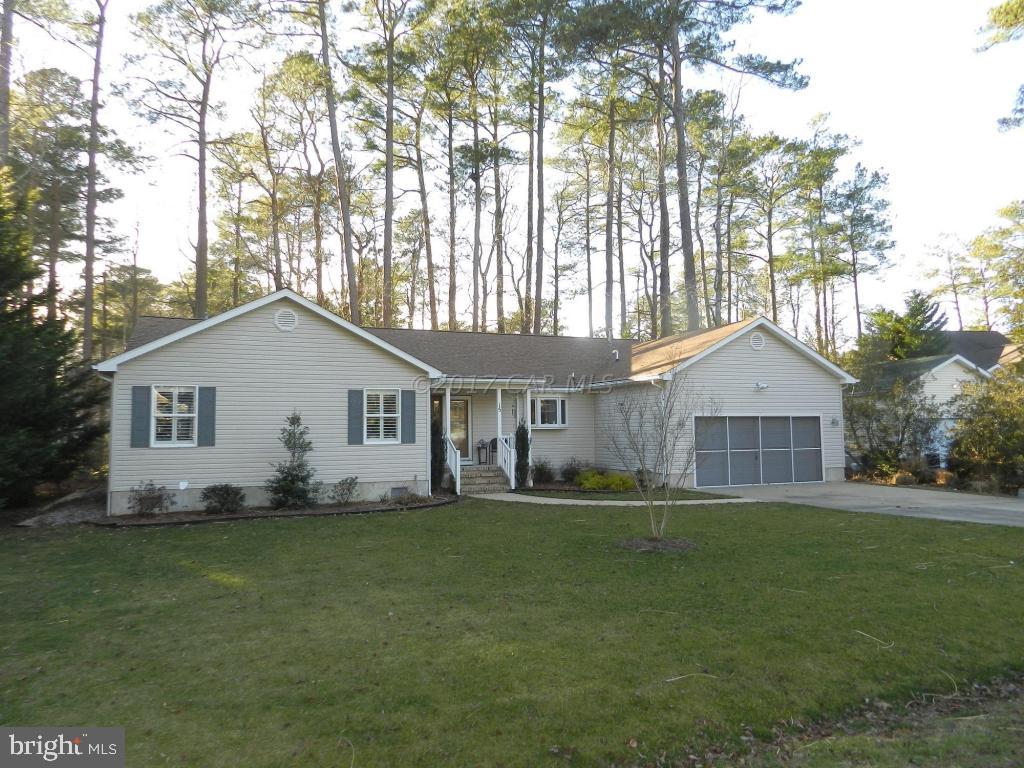 a front view of house with yard and trees in the background