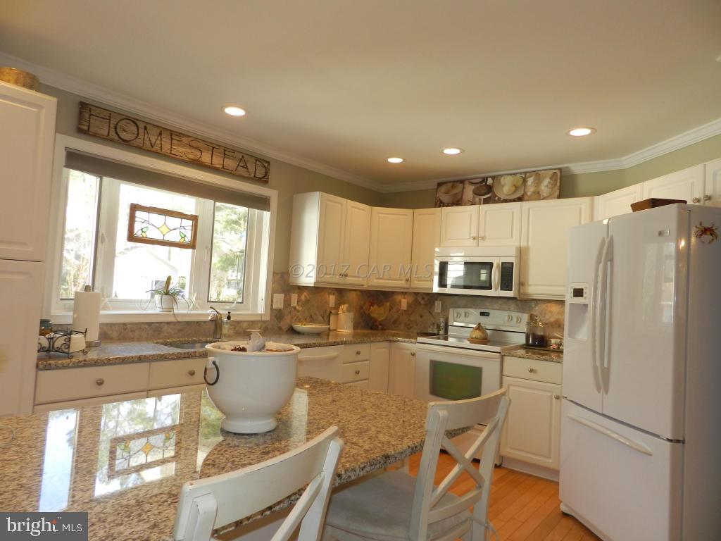 15 Mist Flower Road Berlin, MD 21811 - Photo 3 of 49 a kitchen with kitchen island a large window appliances and chairs