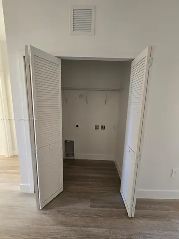 an empty room with wooden floor and a window