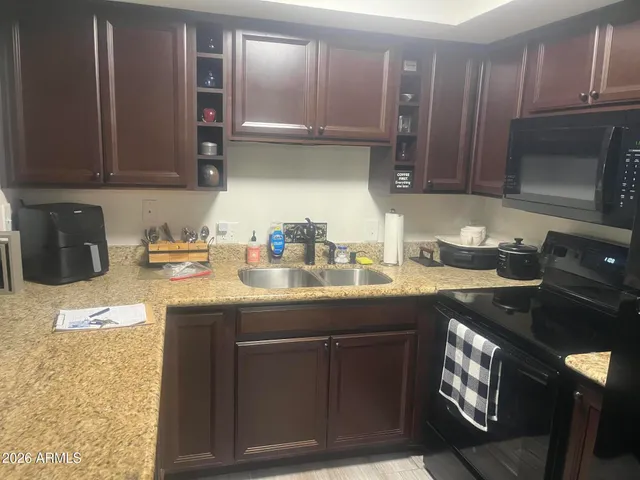 a kitchen with stainless steel appliances granite countertop a sink stove and cabinets