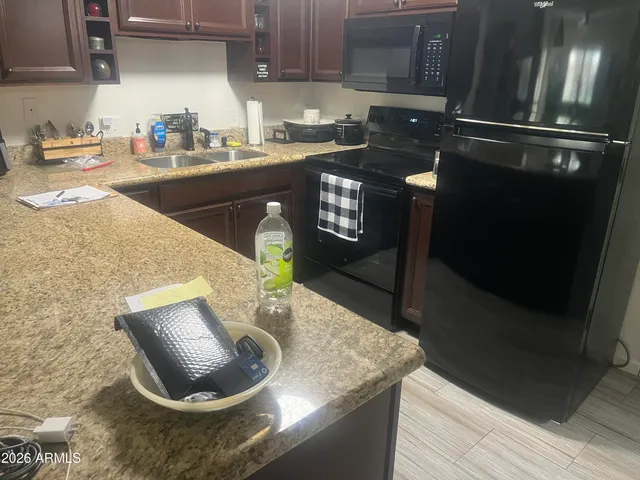 a kitchen with granite countertop a sink a stove and cabinets