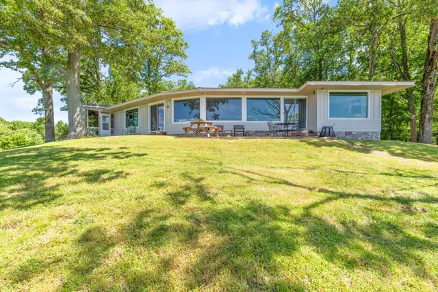 a living room with fireplace furniture and a large window