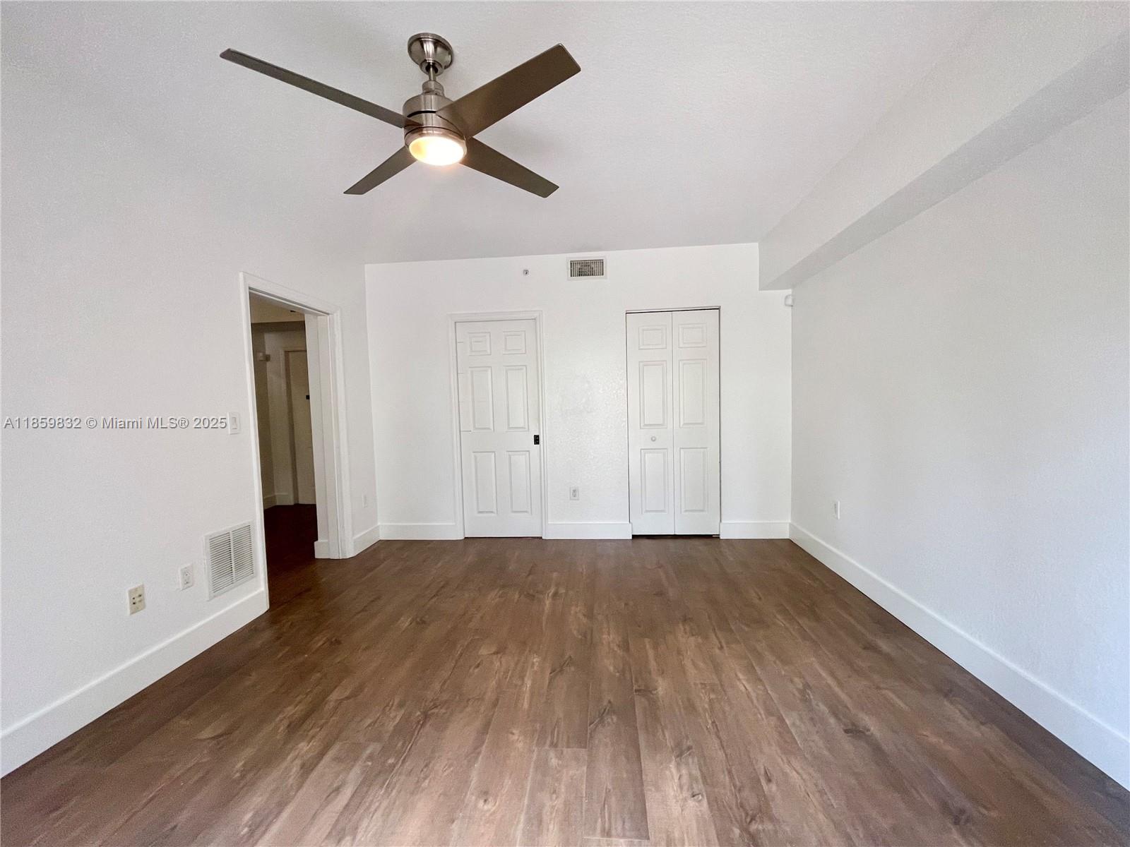 3204 Bird Avenue, Unit 105 Miami, FL 33133 - Photo 13 of 64 an empty room with wooden floor ceiling fan and windows