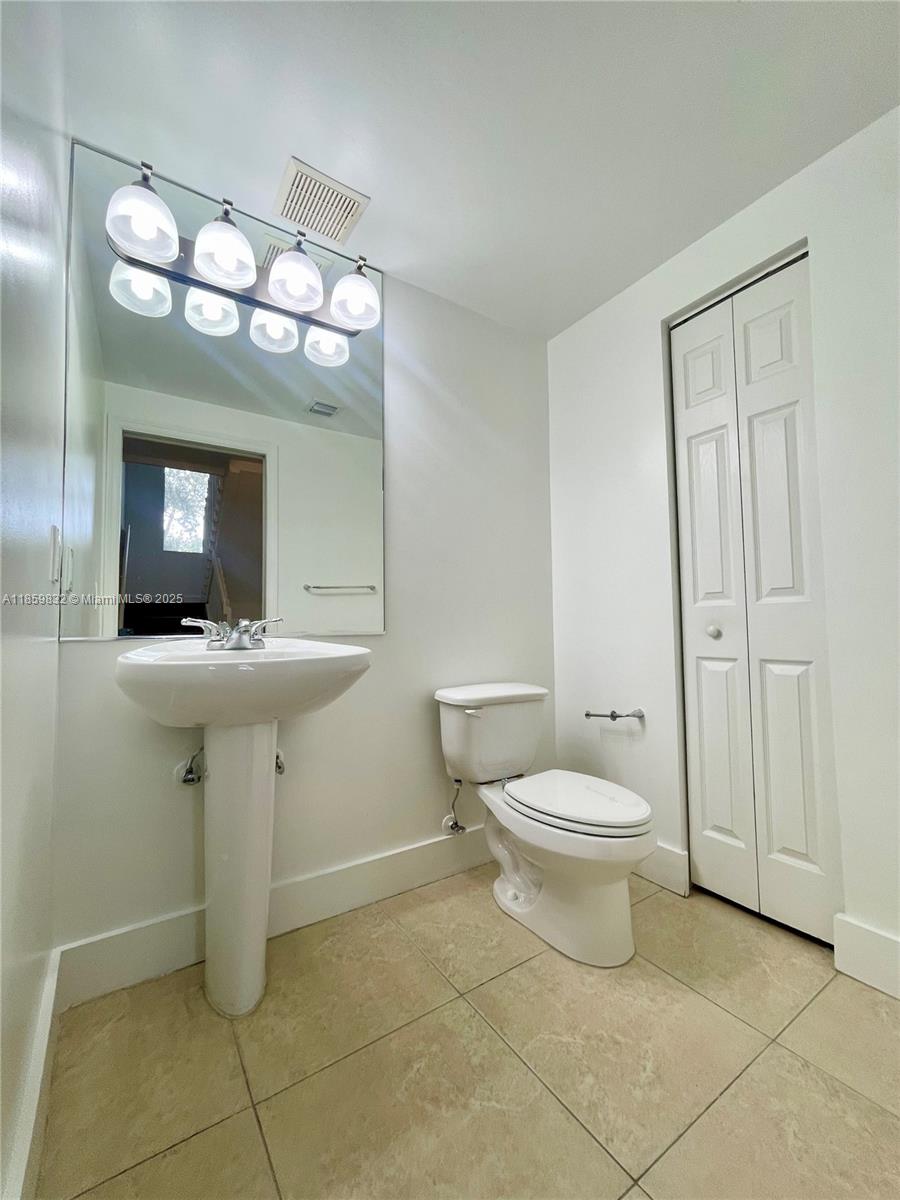 3204 Bird Avenue, Unit 105 Miami, FL 33133 - Photo 23 of 64 a bathroom with a toilet sink and mirror