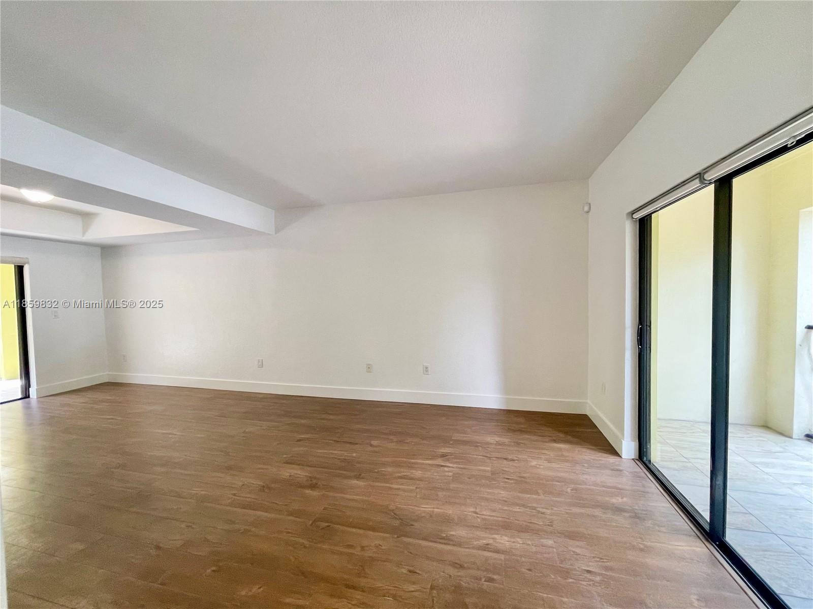 3204 Bird Avenue, Unit 105 Miami, FL 33133 - Photo 24 of 64 a view of an empty room with wooden floor and a window