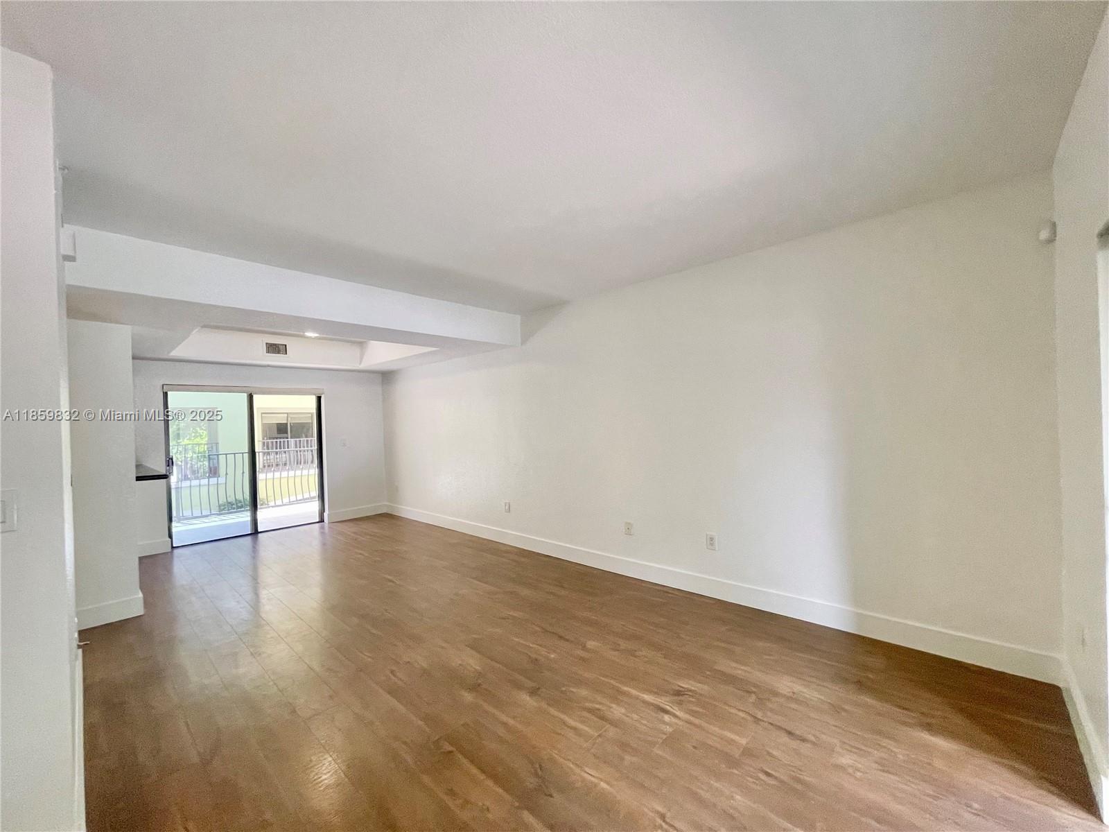 3204 Bird Avenue, Unit 105 Miami, FL 33133 - Photo 25 of 64 an empty room with wooden floor and windows