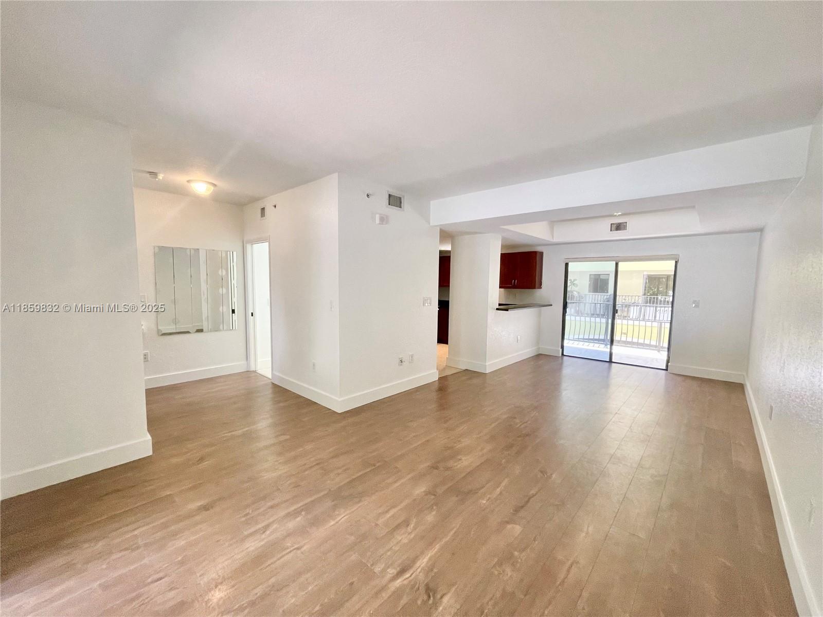 3204 Bird Avenue, Unit 105 Miami, FL 33133 - Photo 28 of 64 a view of an empty room with wooden floor and a window