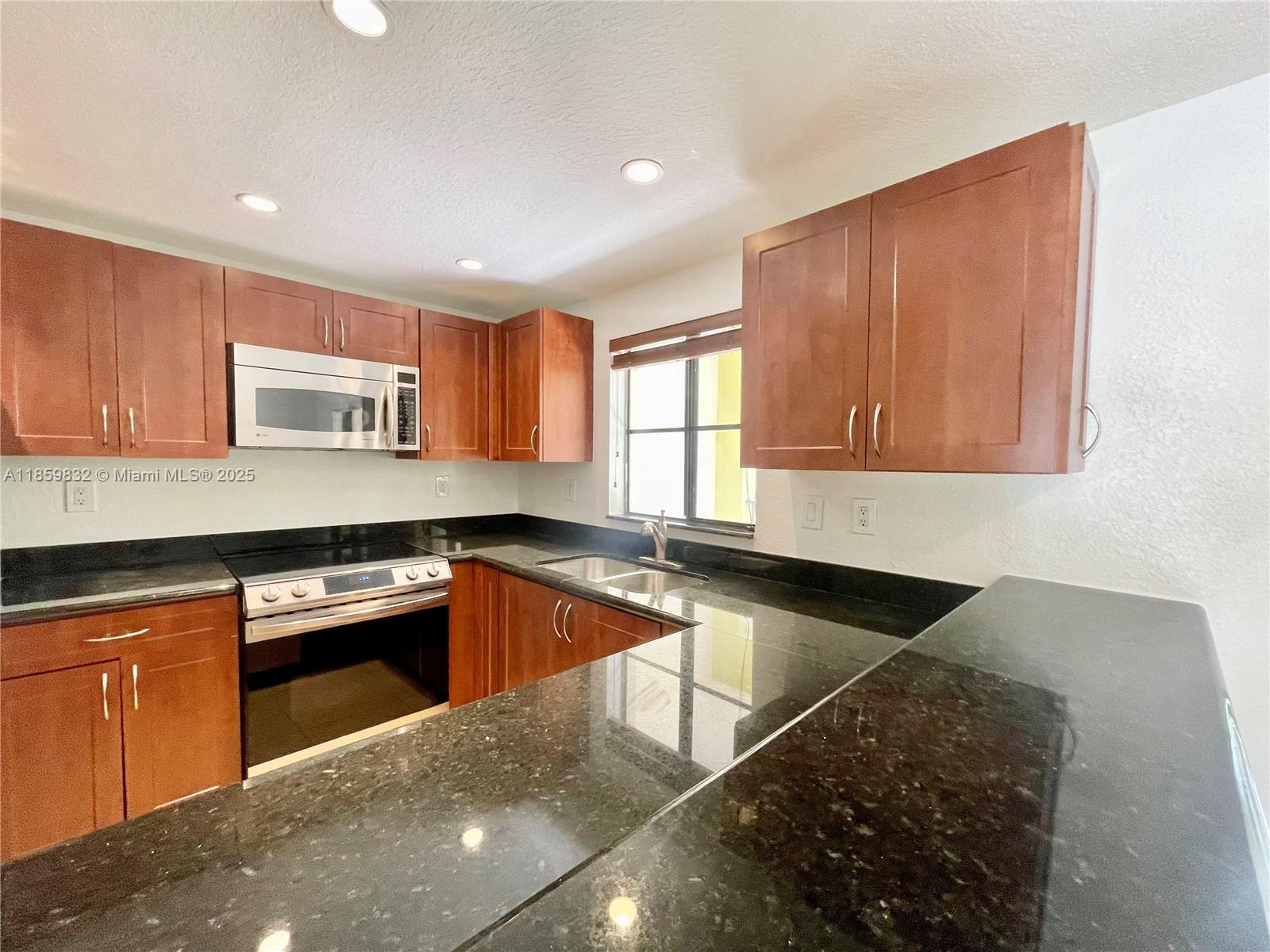 3204 Bird Avenue, Unit 105 Miami, FL 33133 - Photo 34 of 64 a kitchen with granite countertop a sink and a stove
