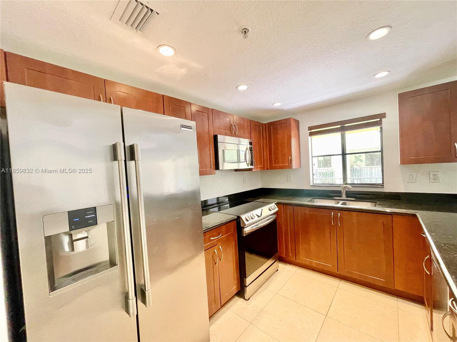 3204 Bird Avenue, Unit 105 Miami, FL 33133 - Photo 35 of 64 a kitchen with stainless steel appliances granite countertop a refrigerator and a sink