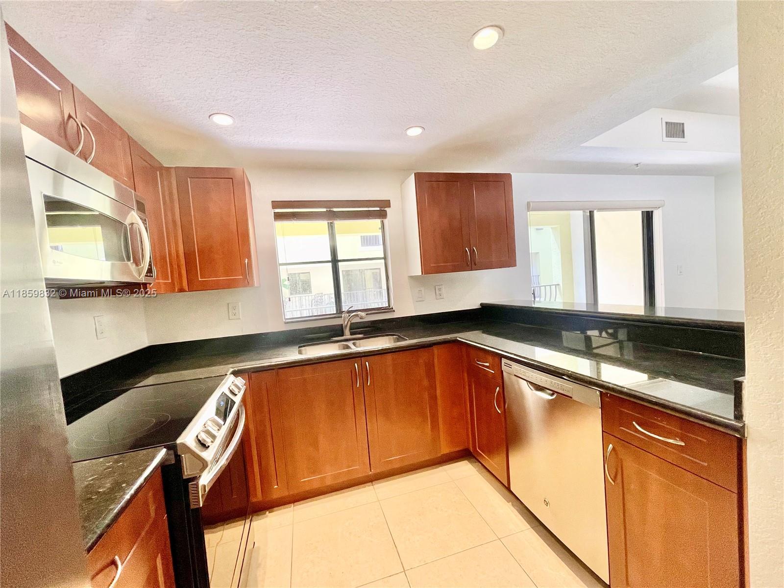 3204 Bird Avenue, Unit 105 Miami, FL 33133 - Photo 36 of 64 a kitchen with granite countertop sink and cabinets