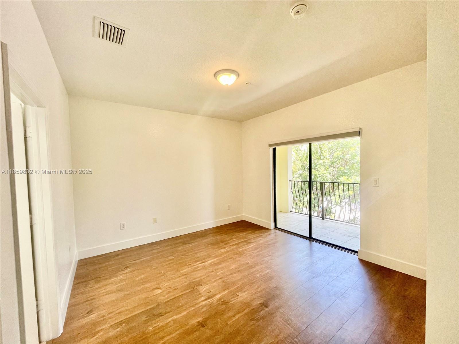 3204 Bird Avenue, Unit 105 Miami, FL 33133 - Photo 45 of 64 a view of an empty room with wooden floor and a window