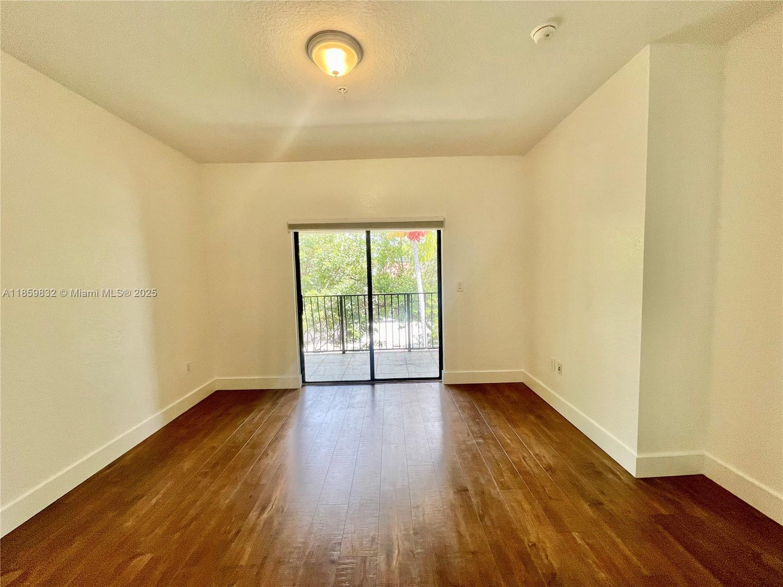 3204 Bird Avenue, Unit 105 Miami, FL 33133 - Photo 51 of 64 an empty room with wooden floor and windows
