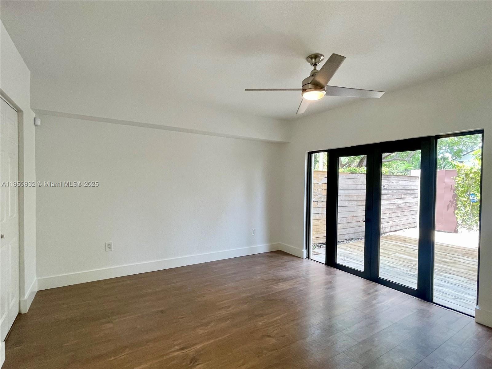 3204 Bird Avenue, Unit 105 Miami, FL 33133 - Photo 9 of 64 an empty room with wooden floor and windows