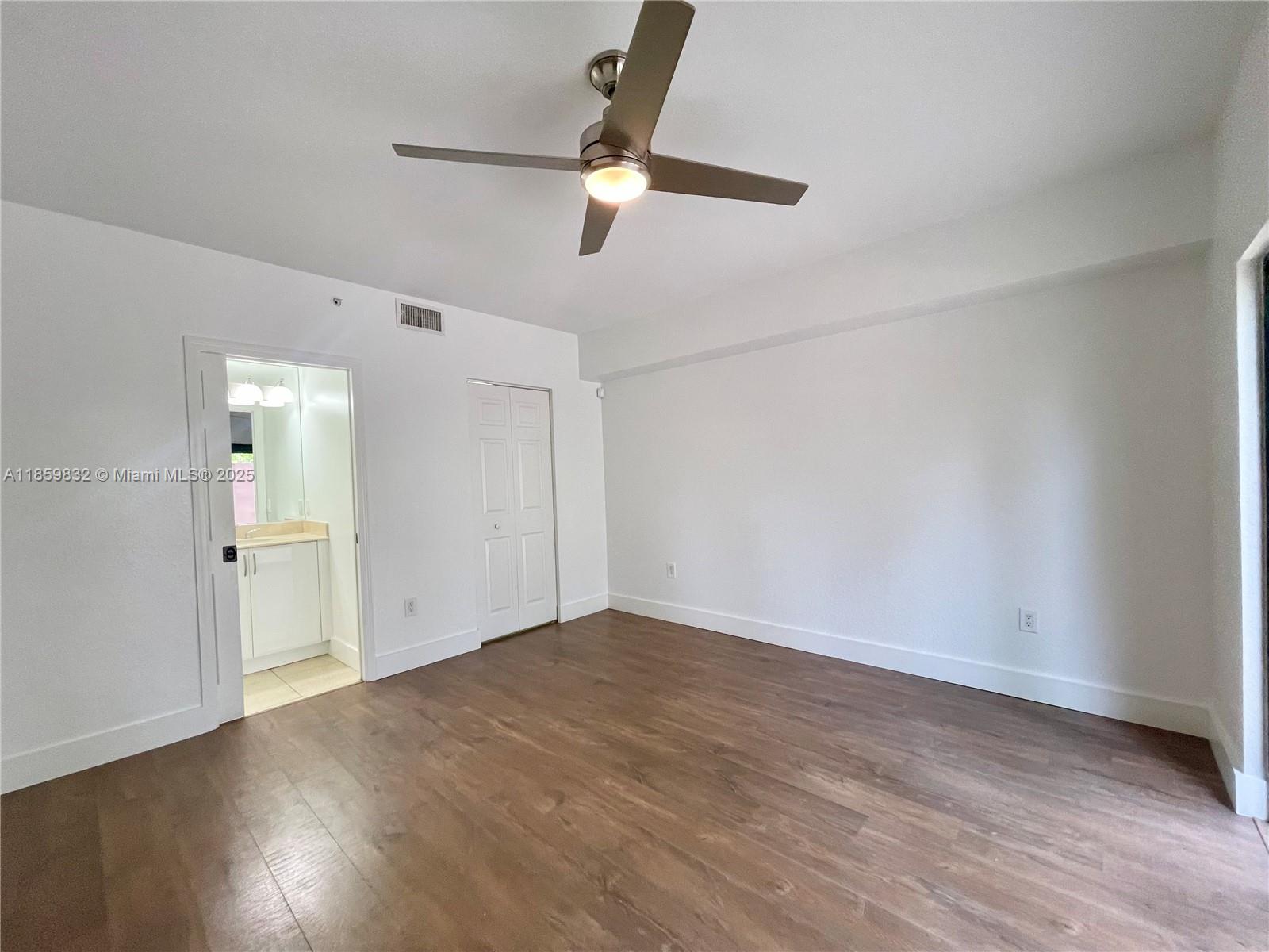 3204 Bird Avenue, Unit 105 Miami, FL 33133 - Photo 10 of 64 an empty room with wooden floor fan and windows