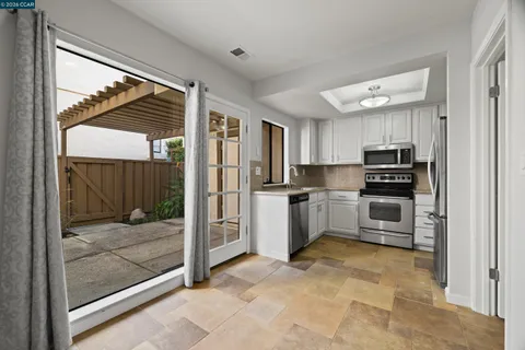 a kitchen with granite countertop a refrigerator and a stove top oven
