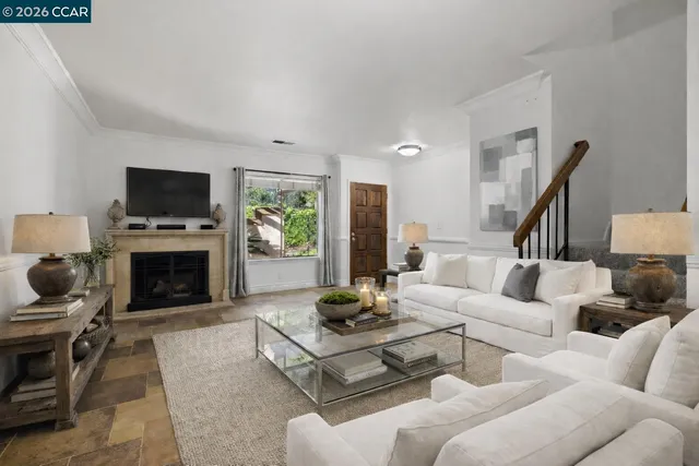 a living room with furniture a fireplace and a flat screen tv