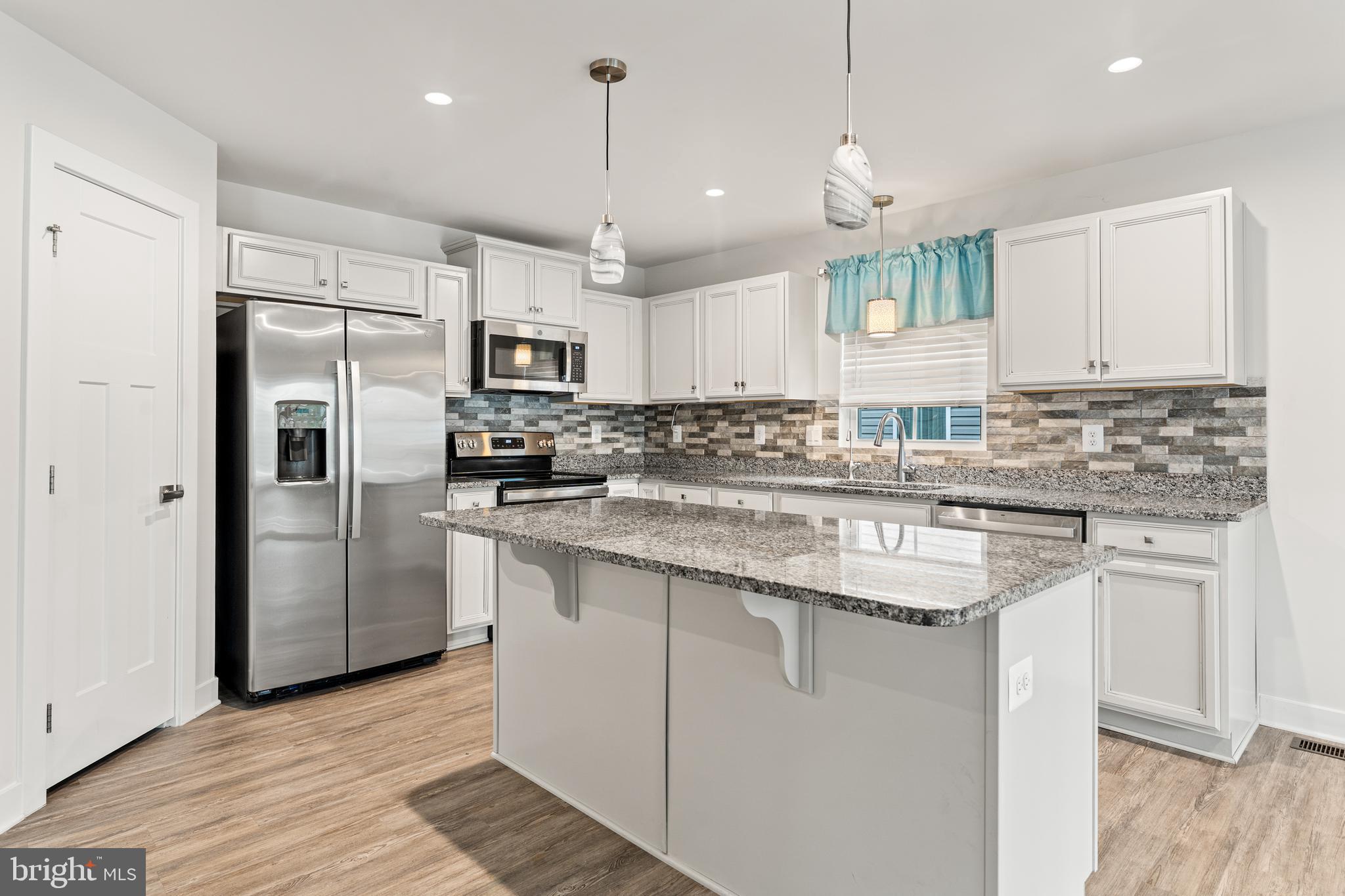 18332 Signature Way Ruther Glen, VA 22546 - Photo 23 of 50 a kitchen with stainless steel appliances granite countertop a sink a stove a refrigerator and cabinets
