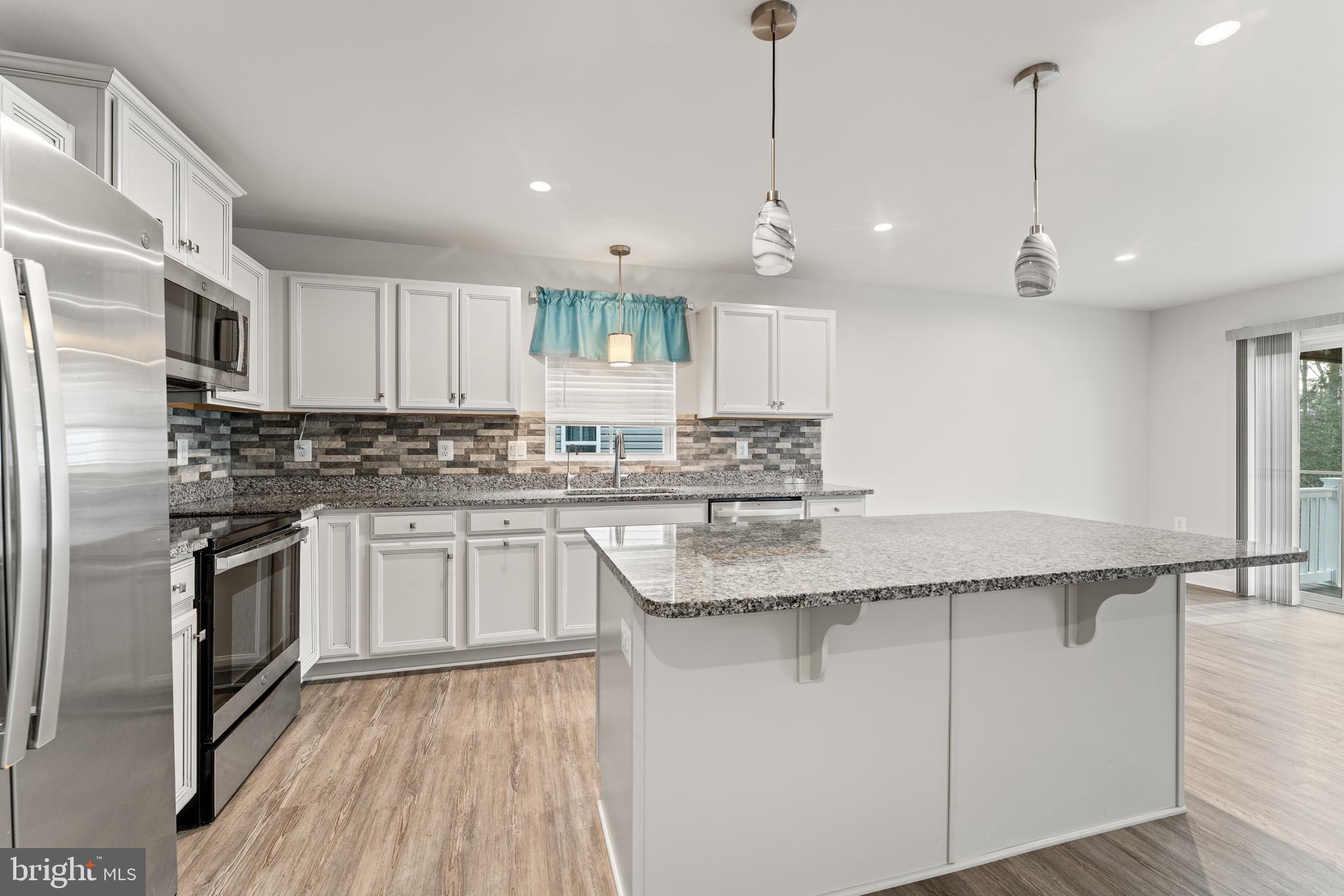 18332 Signature Way Ruther Glen, VA 22546 - Photo 25 of 50 a kitchen with stainless steel appliances granite countertop a sink a stove a refrigerator and island with wooden floor