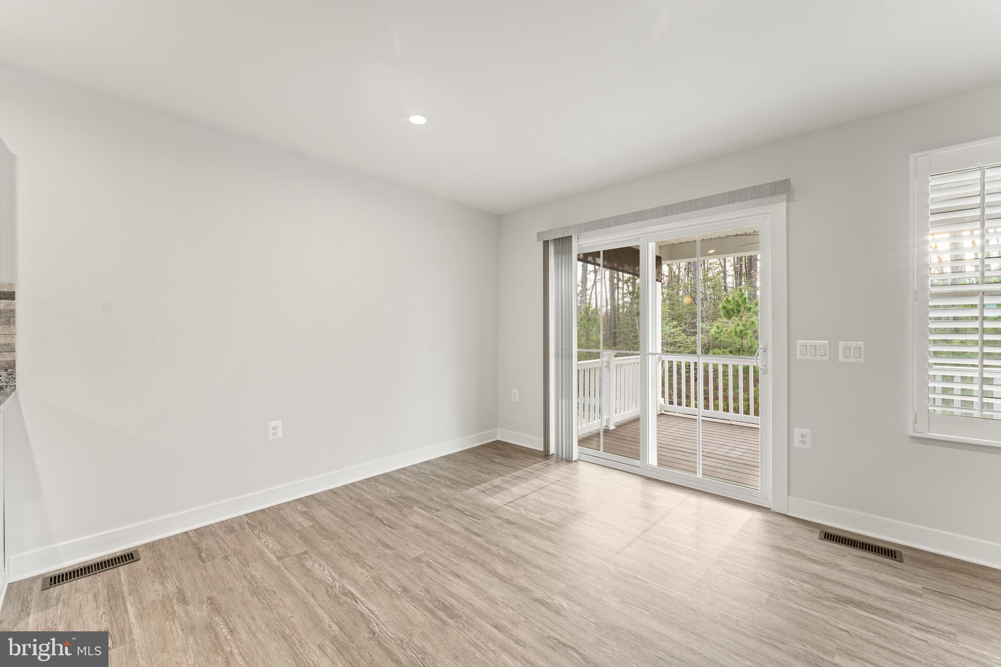 18332 Signature Way Ruther Glen, VA 22546 - Photo 26 of 50 a view of an empty room with wooden floor and a window