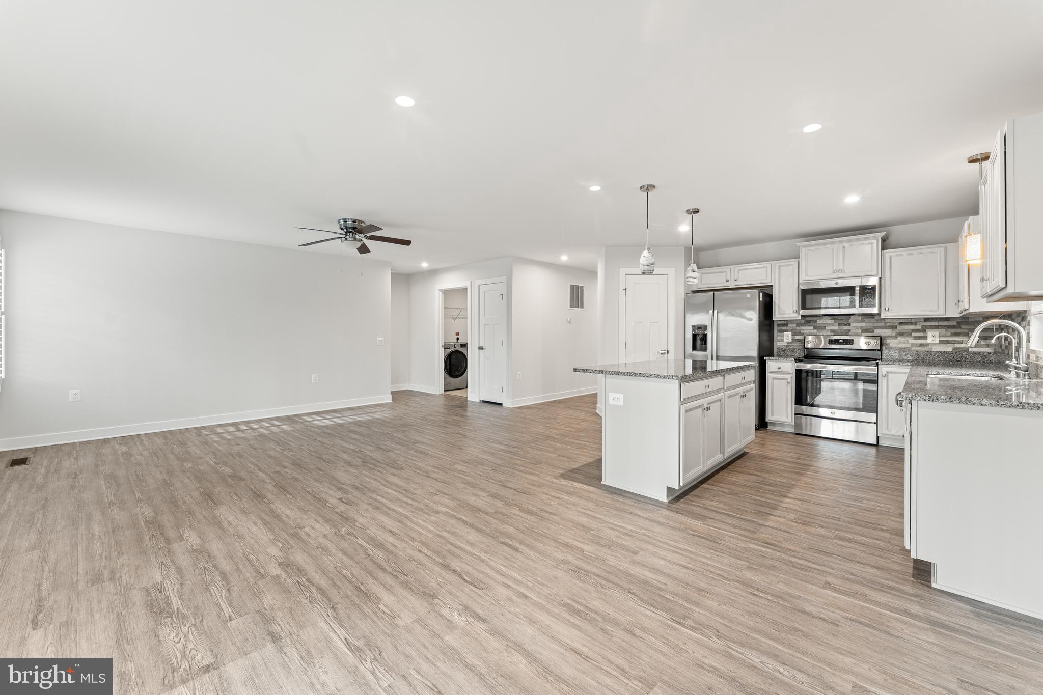 18332 Signature Way Ruther Glen, VA 22546 - Photo 27 of 50 a view of kitchen with kitchen island white cabinets and stainless steel appliances