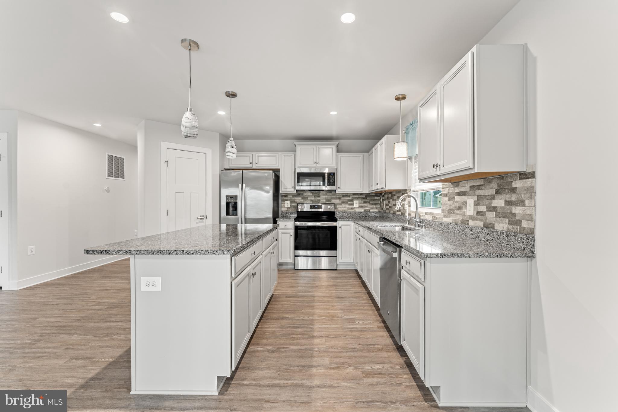 18332 Signature Way Ruther Glen, VA 22546 - Photo 28 of 50 a large kitchen with stainless steel appliances granite countertop a stove top oven a sink and a refrigerator