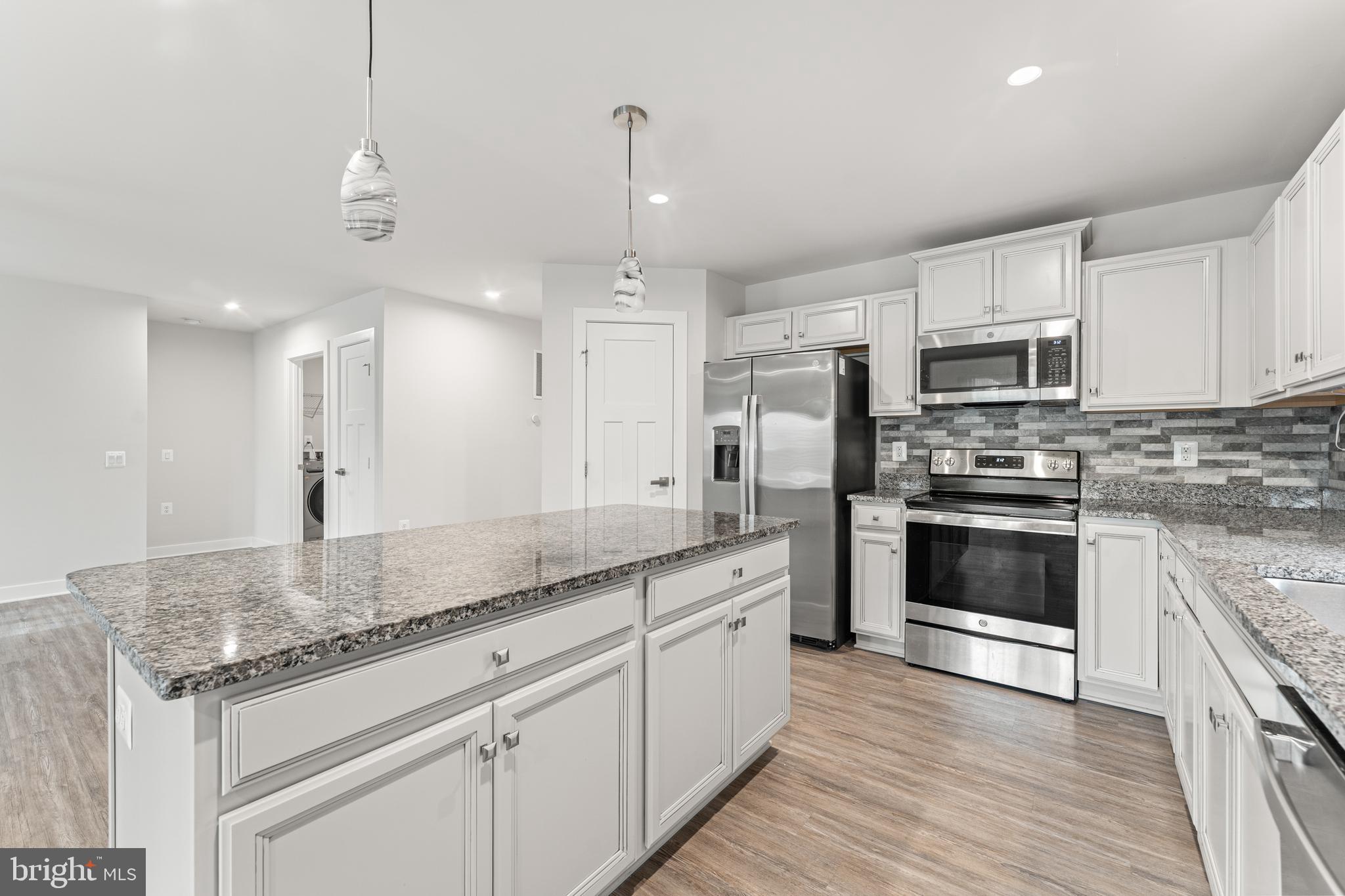 18332 Signature Way Ruther Glen, VA 22546 - Photo 30 of 50 a kitchen with stainless steel appliances granite countertop a stove a sink and a refrigerator