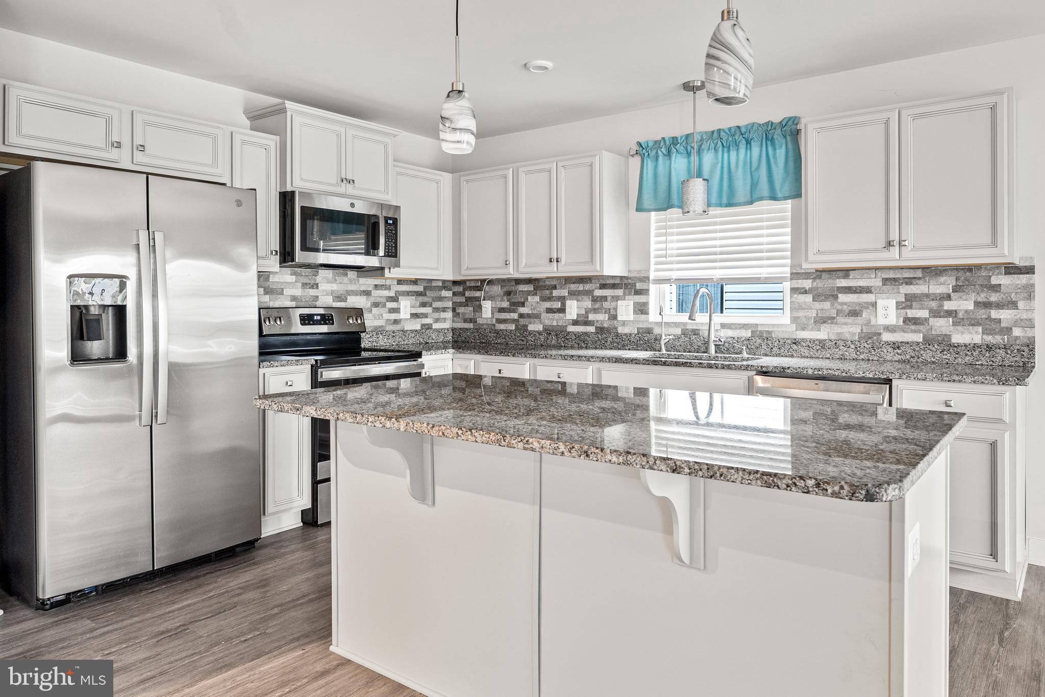 18332 Signature Way Ruther Glen, VA 22546 - Photo 31 of 50 a kitchen with stainless steel appliances granite countertop a sink a stove a refrigerator a center island and cabinets