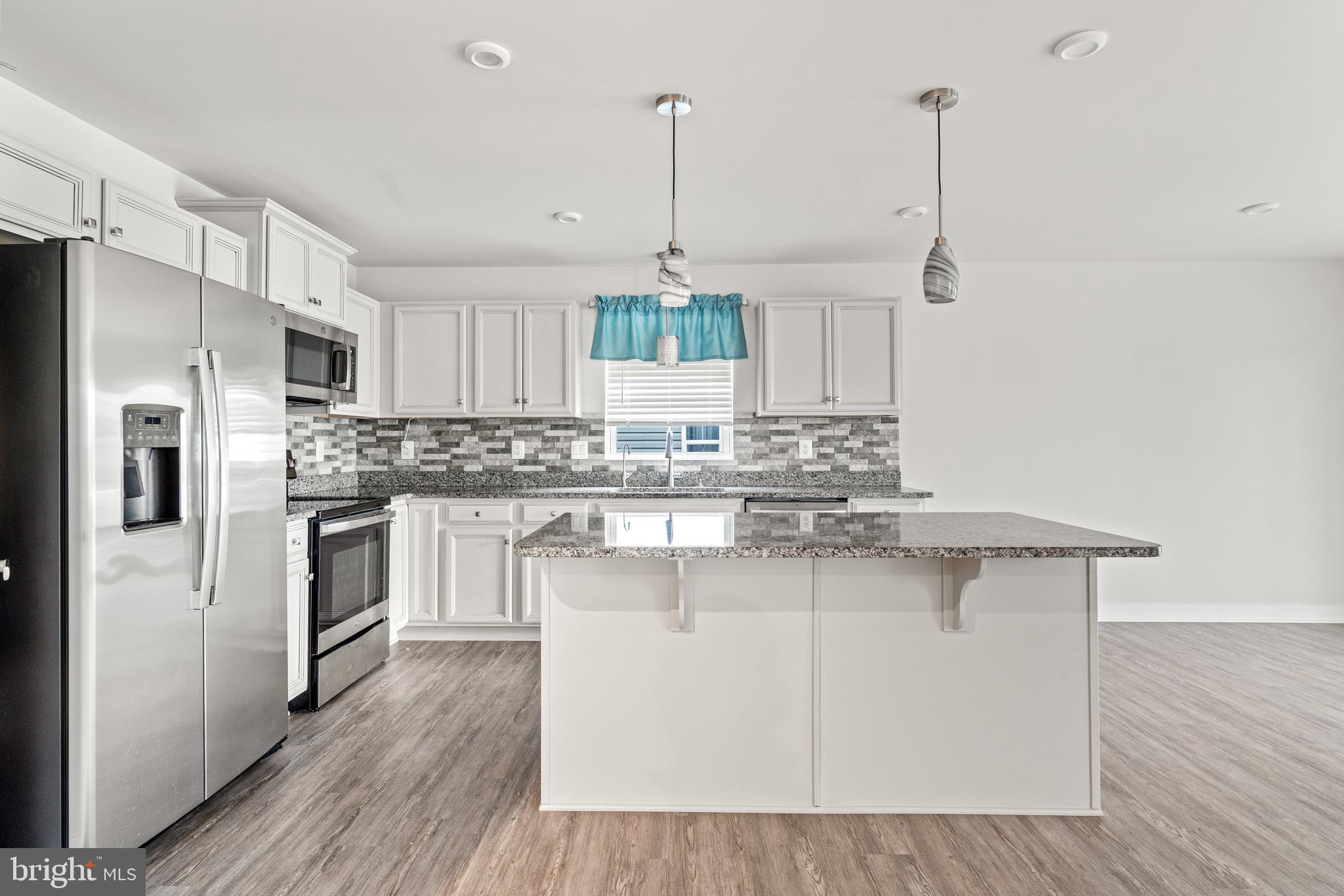 18332 Signature Way Ruther Glen, VA 22546 - Photo 33 of 50 a kitchen with stainless steel appliances granite countertop a stove a sink dishwasher a refrigerator and white cabinets with wooden floor
