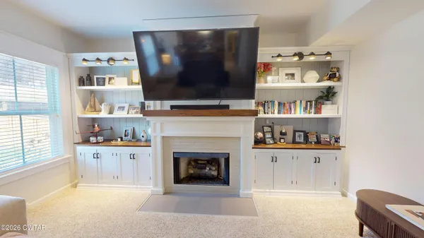 a living room with furniture a flat screen tv and a fireplace