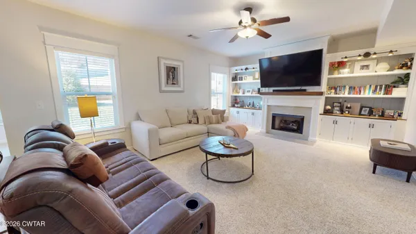 a living room with furniture a flat screen tv and a fireplace