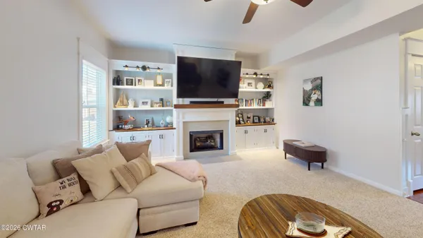 a living room with furniture a flat screen tv and a window