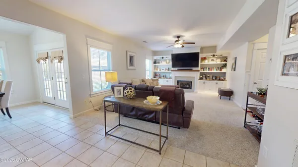 a living room with furniture a flat screen tv and a window