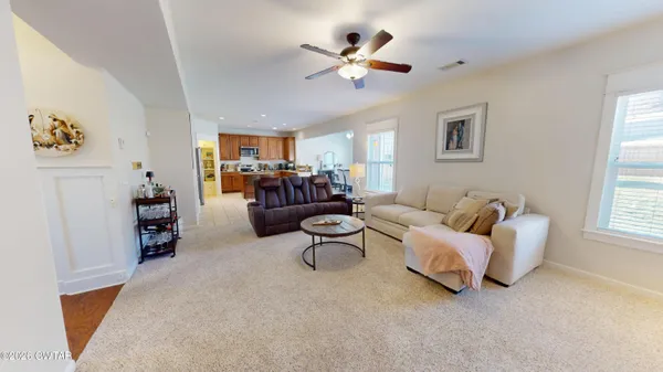 a living room with furniture ceiling fan and a wooden floor
