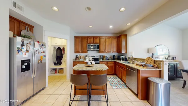 a kitchen with stainless steel appliances granite countertop a stove a sink a microwave and a refrigerator