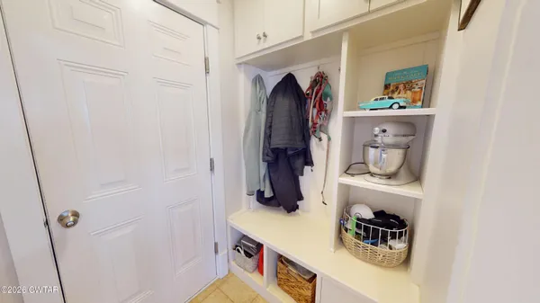 a living room with furniture a flat screen tv and a refrigerator