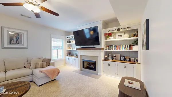 a living room with furniture a flat screen tv and a fireplace